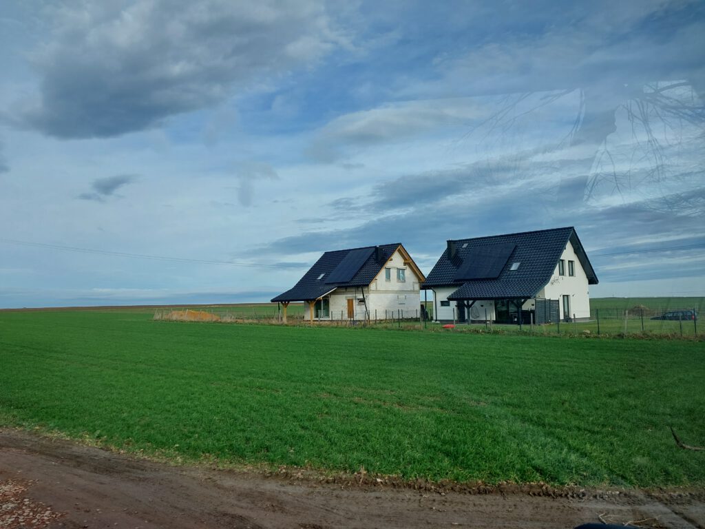 dwa domki z systemami fotowoltaicznymi na dachach
